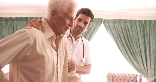 A senior Caucasian man is being assisted by a young Caucasian male nurse, with copy space. Their interaction highlights the compassionate care provided in healthcare settings for the elderly.
