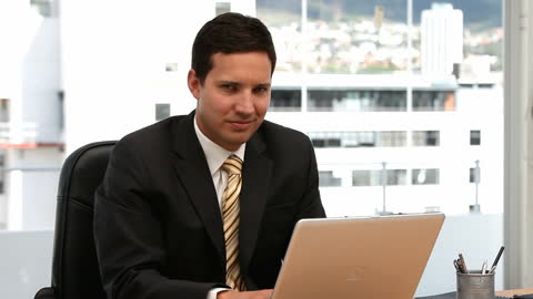 Confident Businessman Working on Laptop in Office Environment