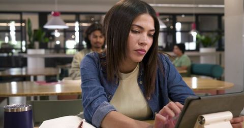 African american woman working on tablet in modern coworking space boosting productivity