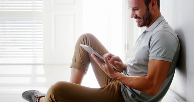 Man Sitting on Floor Using Digital Tablet in Bright Modern Home - Download Free Stock Images Pikwizard.com