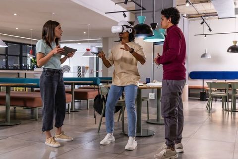 Young multiracial team testing virtual reality headset in modern office lounge