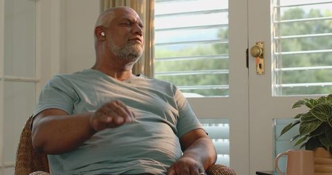 Senior Man Relaxing at Home with Eyes Closed, Enjoying Peace