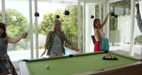 Four Happy Multiracial Female Friends Touring Poolside Room