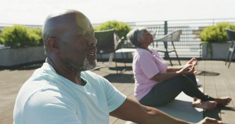 Senior African American Couple Meditating Outdoors with Blend of Sunlight