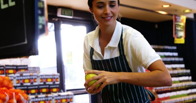 Grocery Store Clerk Holding Fruit and Smiling - Download Free Stock Images Pikwizard.com