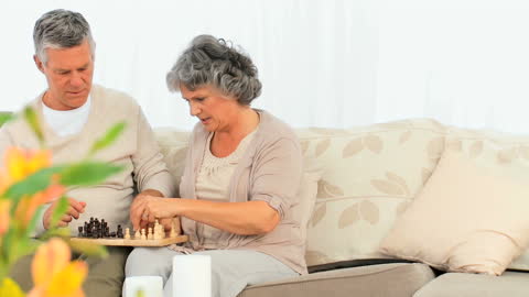 Senior Couple Enjoying Chess in Leisure Time at Home