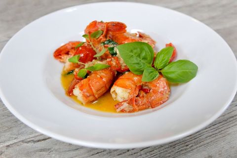 Gourmet shrimp in rich sauce garnished with fresh basil