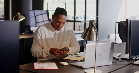Entrepreneur Using Smartphone in Modern Office Workspace