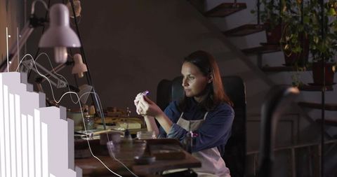 Female Jeweler Inspecting Gemstone at Workbench with Loupe and Studio Lighting