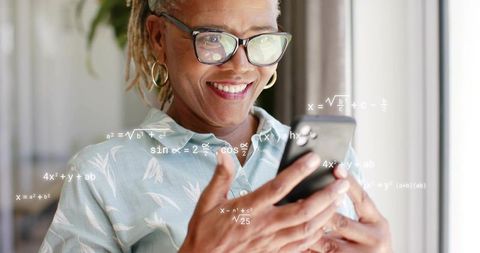 Smiling senior woman solving math on smartphone with augmented equations, learning