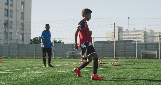 Young soccer player practicing on outdoor field with coach watching - Download Free Stock Images Pikwizard.com