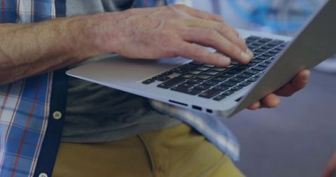 Mature Man Typing on Laptop in Cozy Office Lounge