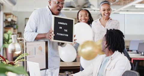 Diverse Team Celebrating Colleague's Promotion in Office