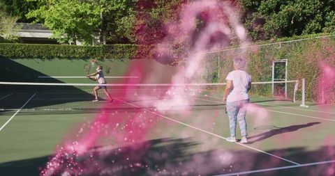 Mature Couple Playing Tennis with Pink Smoke Effect