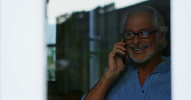 Senior Man Talking on Mobile Phone Through Glass Pane - Download Free Stock Images Pikwizard.com
