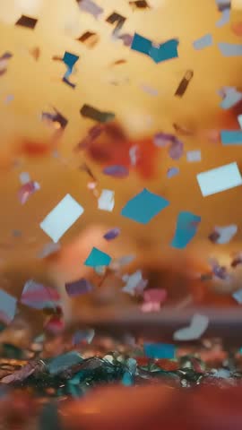 Vertical confetti fluttering and drifting over table in slow-motion celebration scene