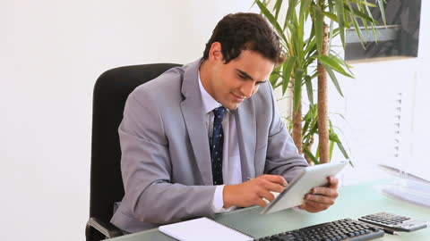 Confident Businessman Using Tablet in Office Setting