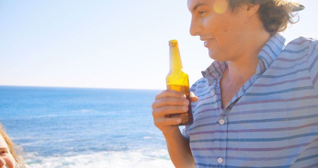 Man Relaxing at Beach with Beer Bottle and Bright Sunlight - Download Free Stock Images Pikwizard.com