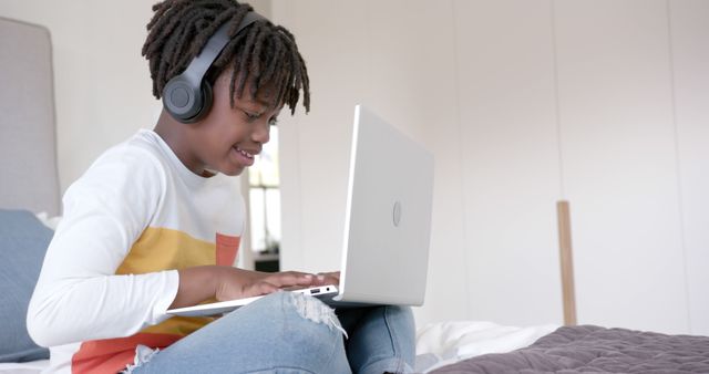 Smiling Child with Headphones Using Laptop at Home - Download Free Stock Images Pikwizard.com