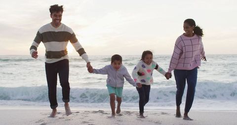 Happy Family Enjoying Fun on Beach at Sunset
