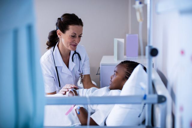 Female doctor offering emotional support and medical care to young patient in a hospital ward. Suitable for healthcare articles, medical brochures, pediatric care promotions, and empathy in healthcare campaigns.