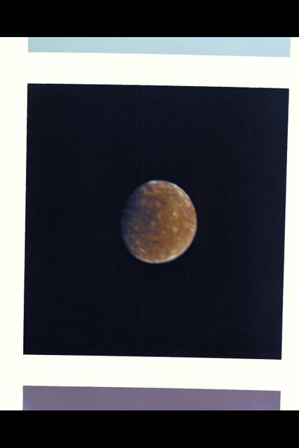 Callisto ,  The outermost Galilean Satellite , or Moon ,  of Jupiter, as taken by Voyager I .  Range : About 7 Million km (5 Million miles) .  Callisto, the darkest of the Galilean Satellites, still nearly twice as bright as the Earth's Moon, is seen here from the face that always faces Jupiter.  All of the Galilean Satellites always show the same face to Jupiter, as the Earth's moon does to Earth. The Surface  shows a mottled appearance of bright and dark patches. The former reminds scientists of rayed or bright  haloed craters, similiar to those seen on earth's Moon. This color photo is assembled from 3 black and wite images taken though violet, orange, & green filters