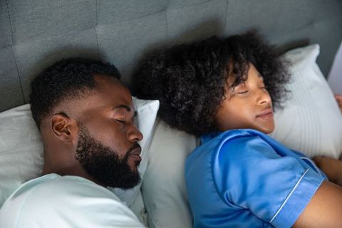 Diverse Couple Sleeping Peacefully in Comfortable Bed
