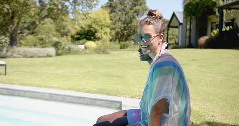 Woman Relaxing by Pool on Sunny Day Outdoors