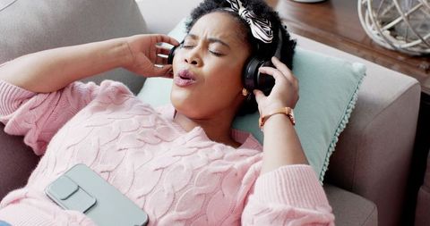 Woman Lounging and Listening to Music with Headphones