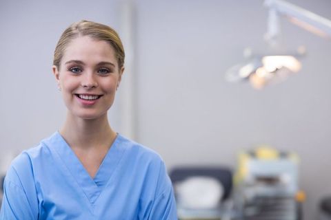 Smiling Nurse in Scrubs in Medical Treatment Room