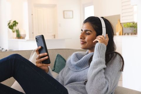 Woman Relaxing at Home with Headphones and Smartphone