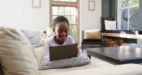 Young Girl Relaxing with Tablet in Contemporary Living Room Setting