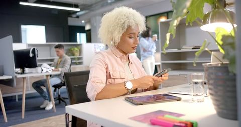 Entrepreneur Working with Smartphone and Laptop in Modern Office