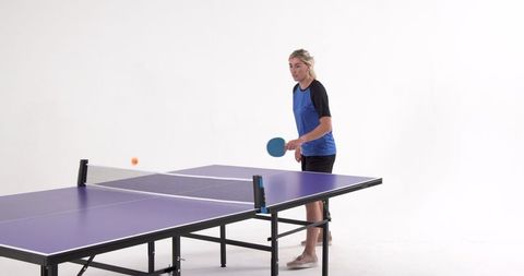 Woman in Sportswear Playing Table Tennis in Minimalist Studio