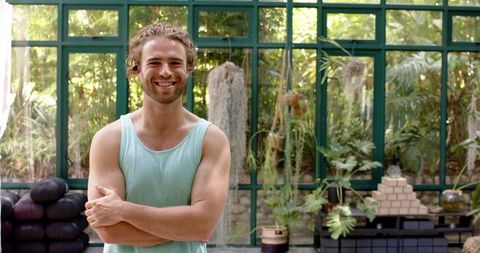 Smiling Man in Casual Wear in Lush Glasshouse Garden