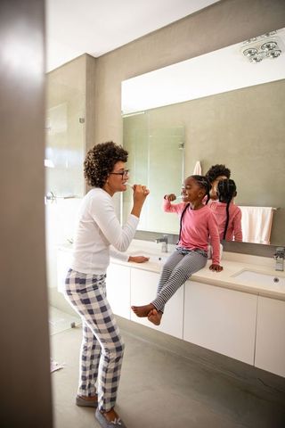 Family brushing routine in stylish modern bathroom