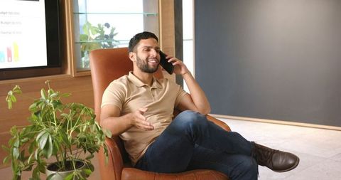 Young professional talking on smartphone in modern office interior