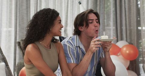 Diverse Couple Celebrating Birthday with Candle on Cupcake