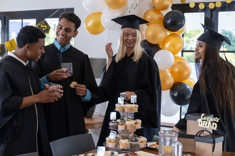Diverse Group of Friends Celebrating Graduation with Toast and Treats