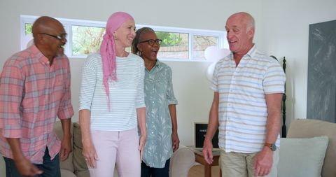 Senior friends laughing together at home enjoying joyful reunion