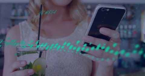 Holding smartphone and cocktail while checking phone in bar with neon data waveform overlay