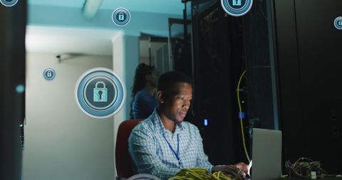 Cybersecurity professional working in data center on laptop