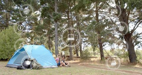 Two Women Sitting at Blue Tent in Pine Forest Camping Relaxing with Digital HUD Overlay