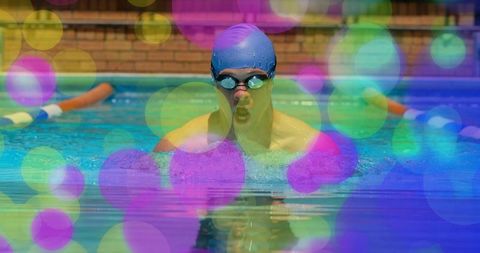 Male Swimmer Emerging from Pool Breaststroke with Vibrant Bokeh Lights, Goggles and Cap