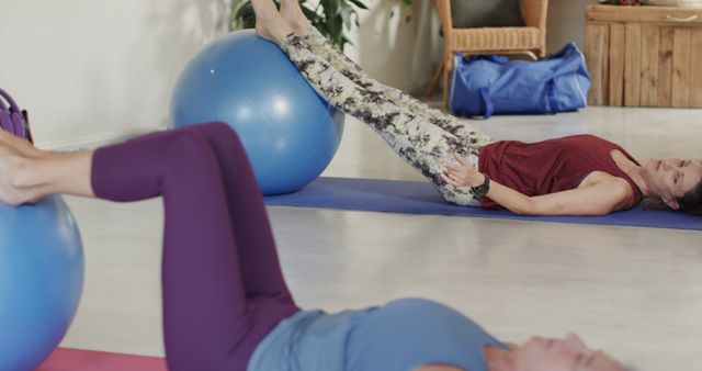 Women engaging in physical exercises using stability balls during a fitness class. Ideal for use in promoting fitness classes, yoga studios, workout routines, healthy living, and gym advertisements.