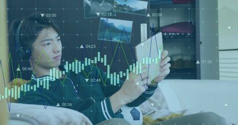 Teen relaxing on sofa using tablet and headset viewing finance charts and mobile analytics
