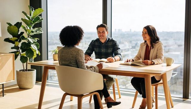Conducting job interview in modern office with two interviewers and candidate with city view