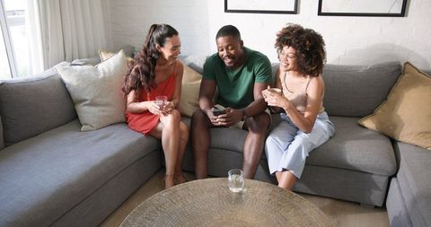 Diverse Friends Socializing on Comfortable Gray Sofa
