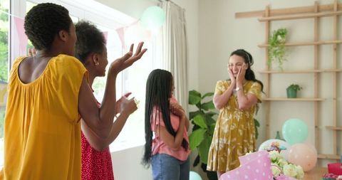Women Celebrating Birthday with Gifts and Laughter at Home Gathering