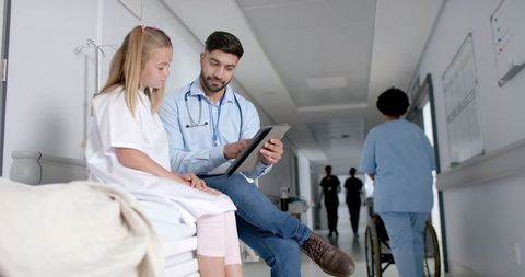 Doctor Discussing Test Results with Young Patient in Hospital Hallway